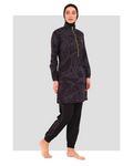 Model in dark patterned burkini with lime green zipper, side view.