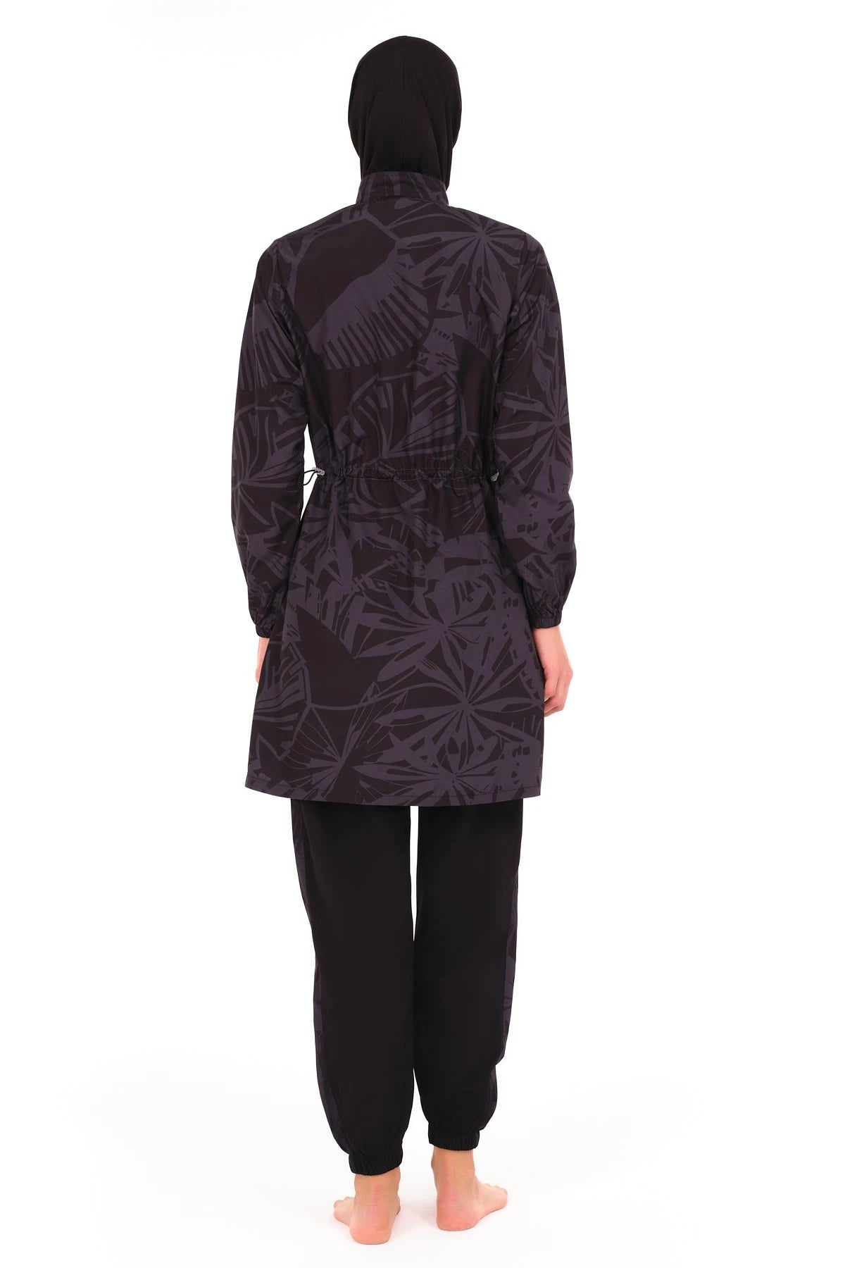 Model in dark patterned burkini set, back view showing adjustable waist.