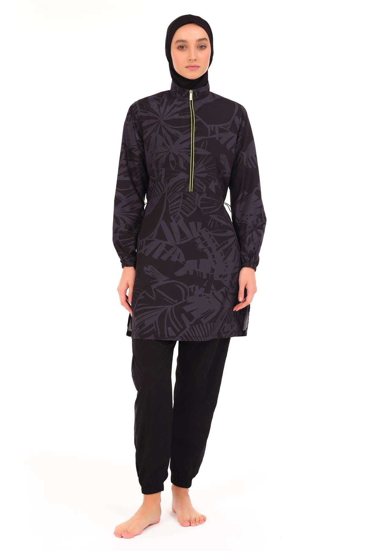 Model in sporty dark patterned burkini with lime green zipper, front view.