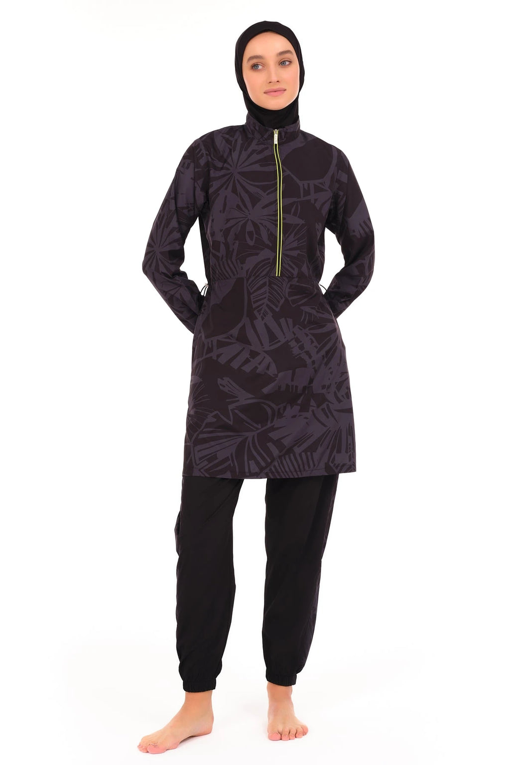 Model in full coverage dark burkini with hands behind back, front view.