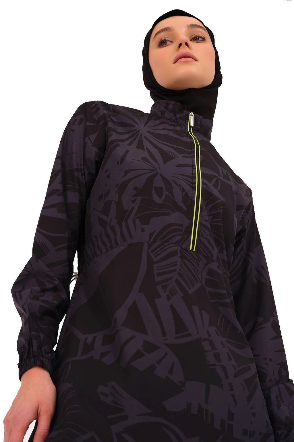 Close-up of dark patterned burkini top with lime green zipper and hijab.
