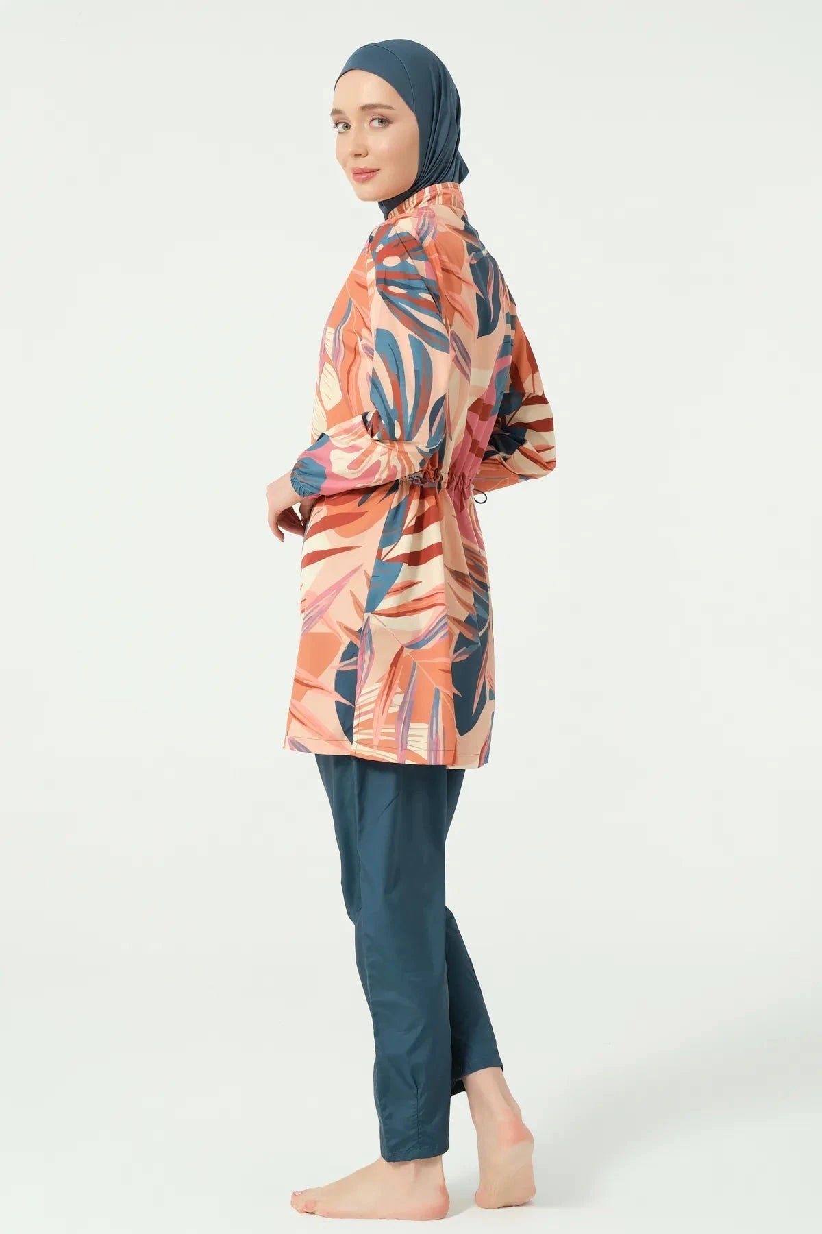 Model in petrol peach tropical burkini set back view.