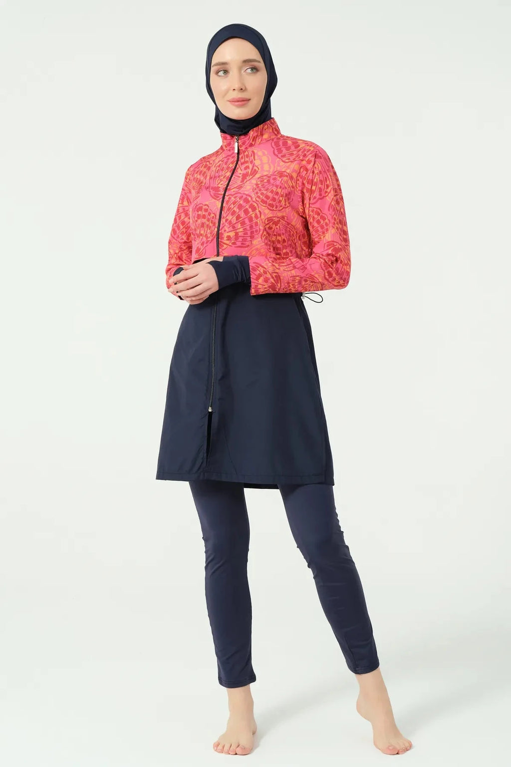 Woman in navy and coral burkini with hands clasped.