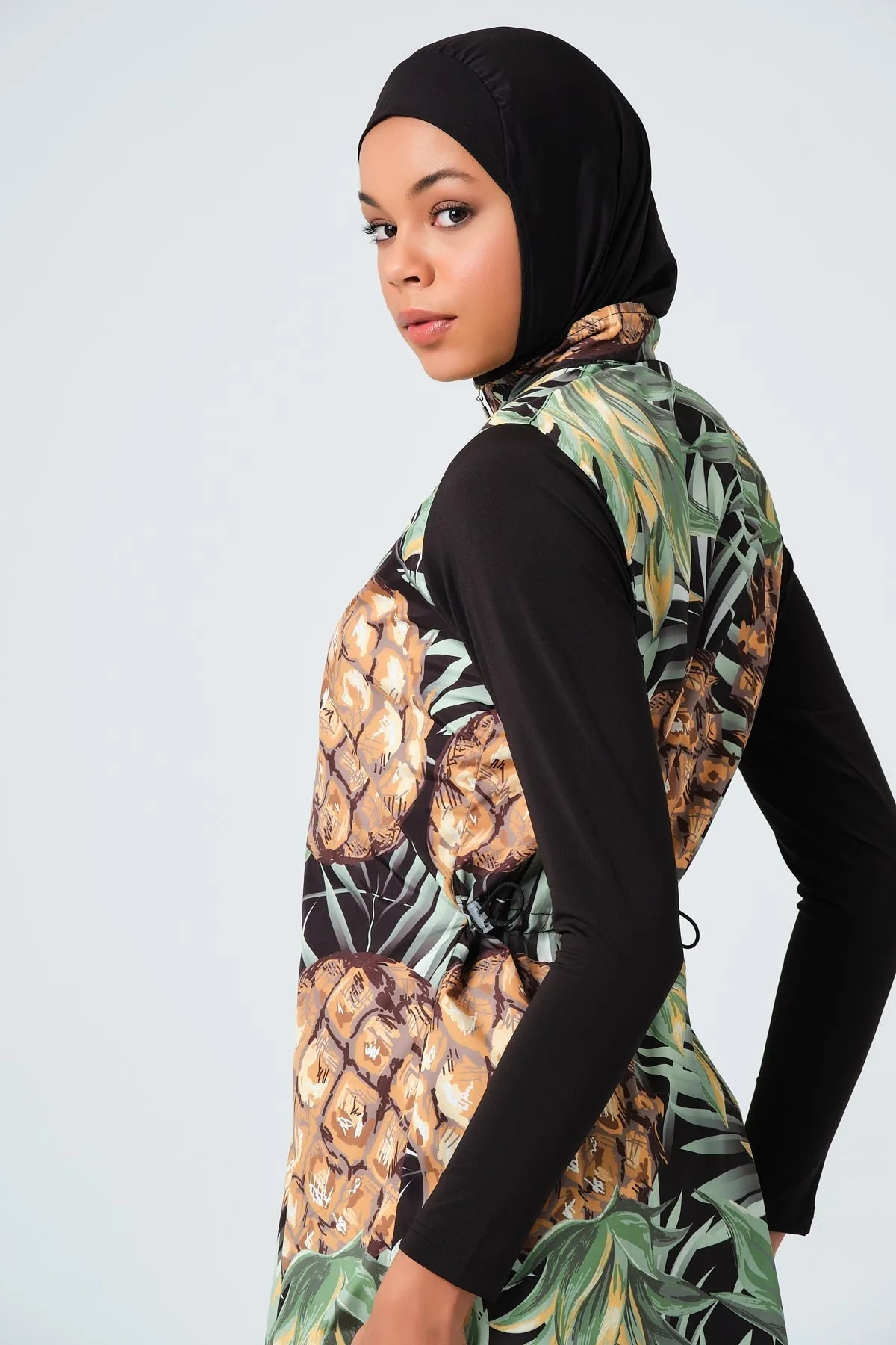 Close-up of model's face wearing black hijab and burkini top.