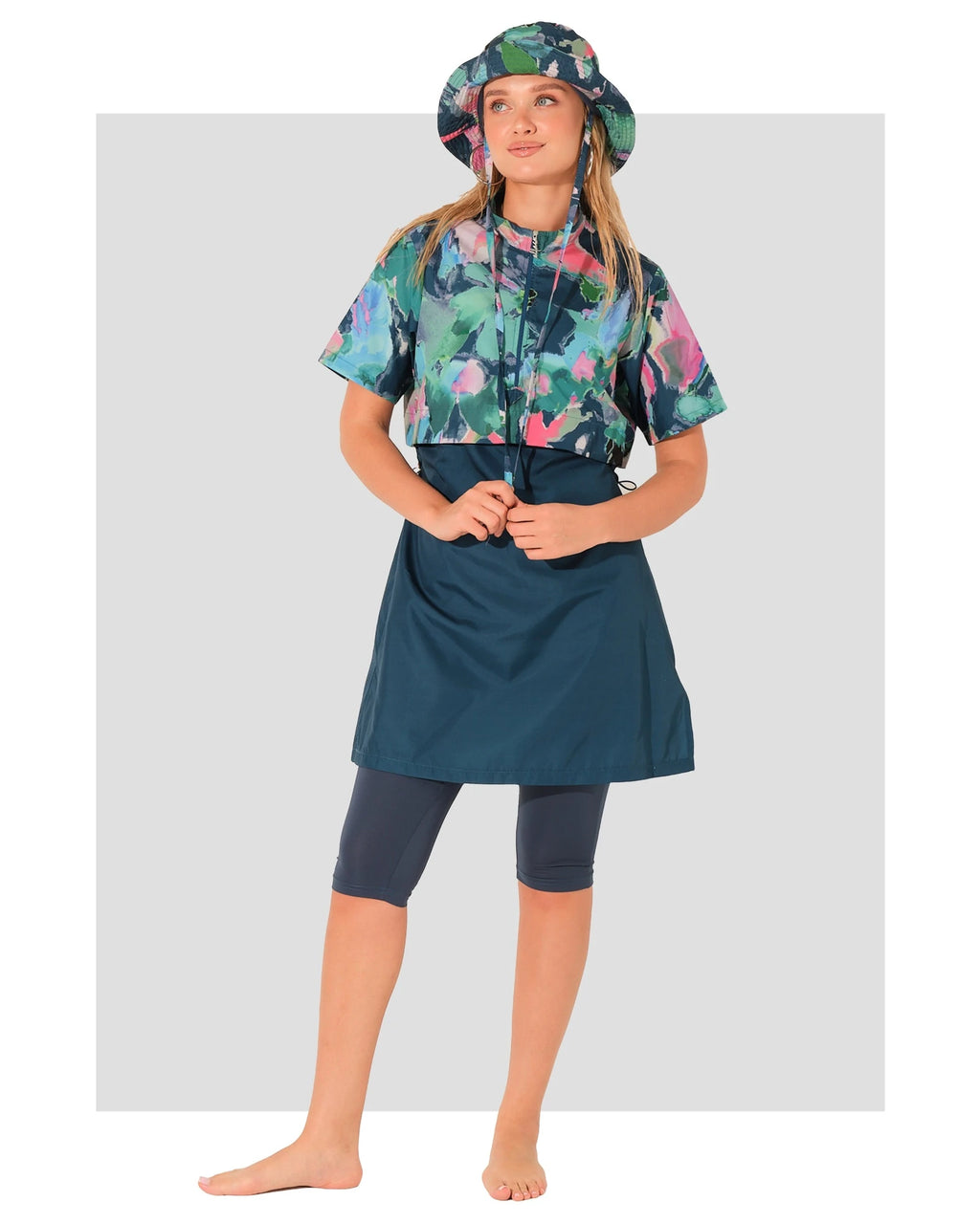 Woman wearing water-repellent burkini set with floral top and bucket hat.