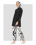 Woman in black tunic and zebra print burkini pants with matching hijab.