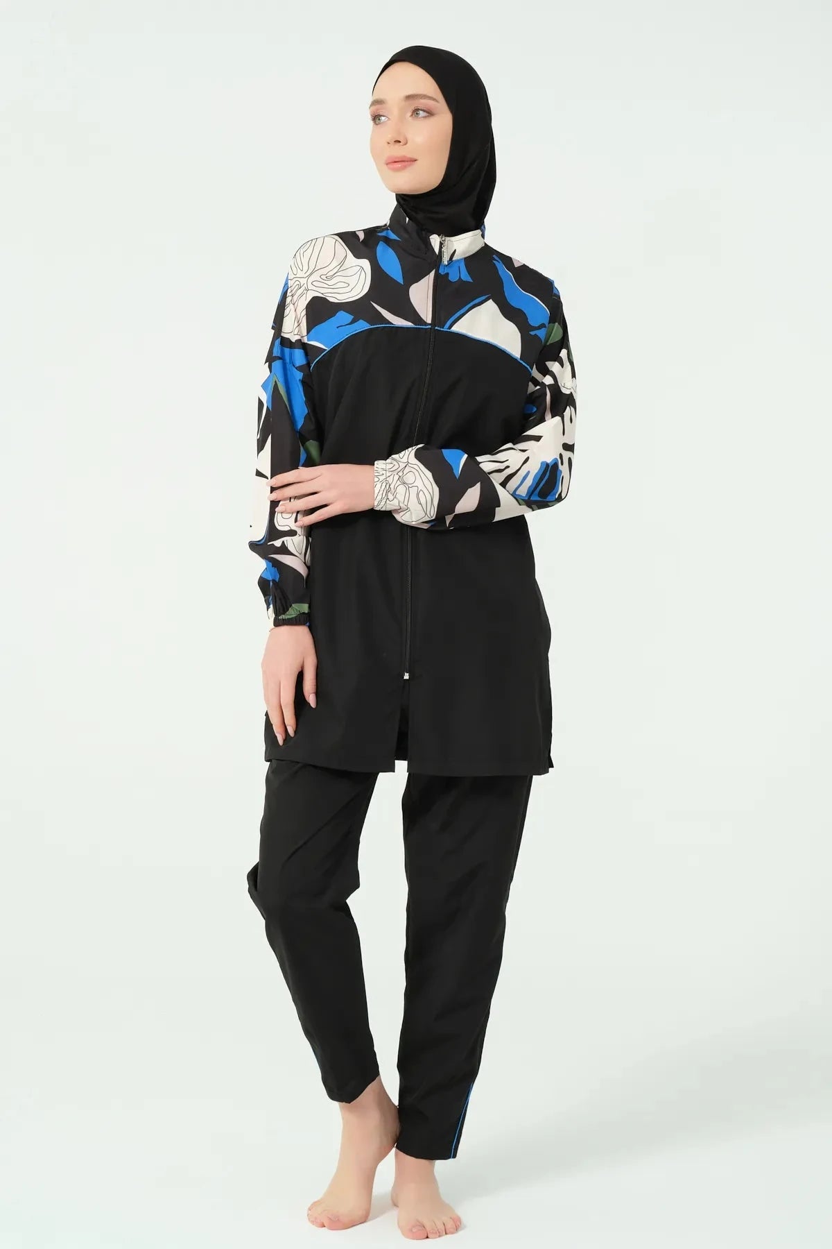 Black full coverage swimwear with abstract print, standing pose.