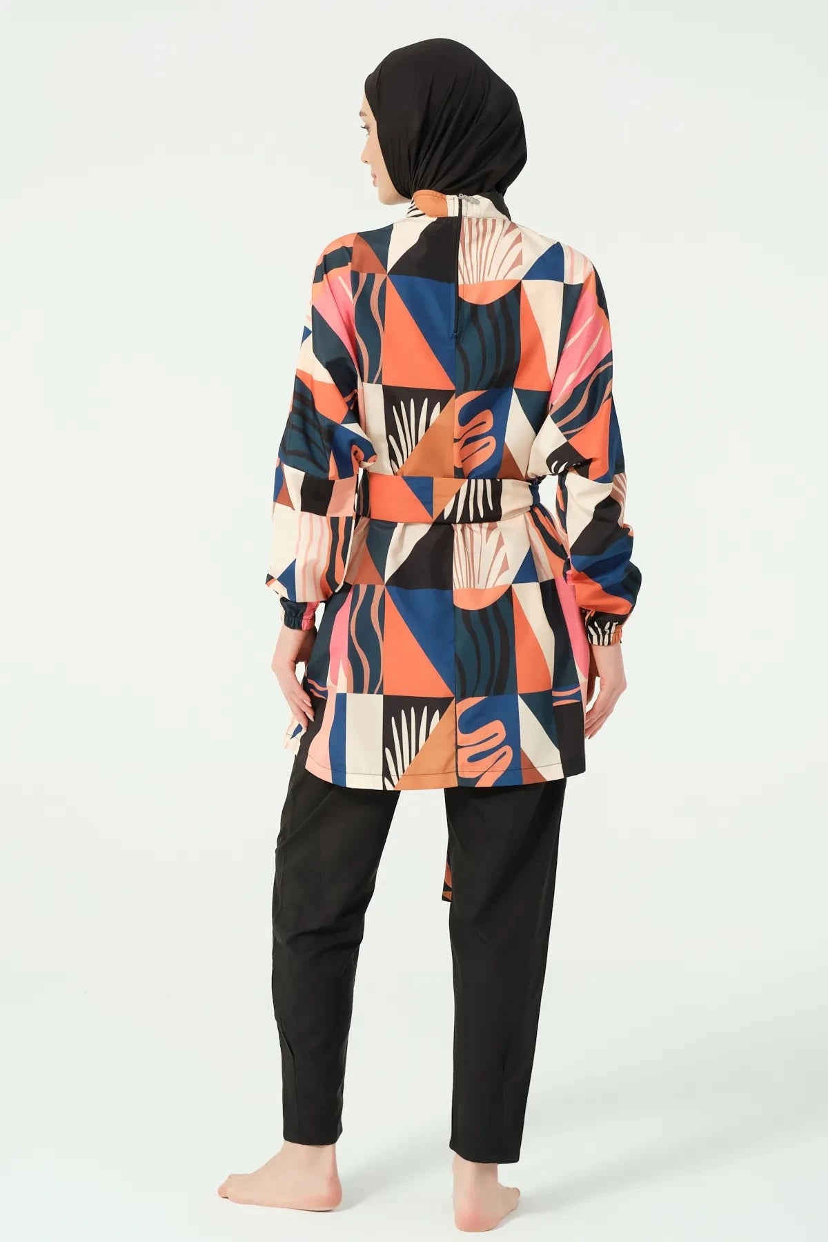 Back view of woman in multi-color geometric print modest swimsuit.