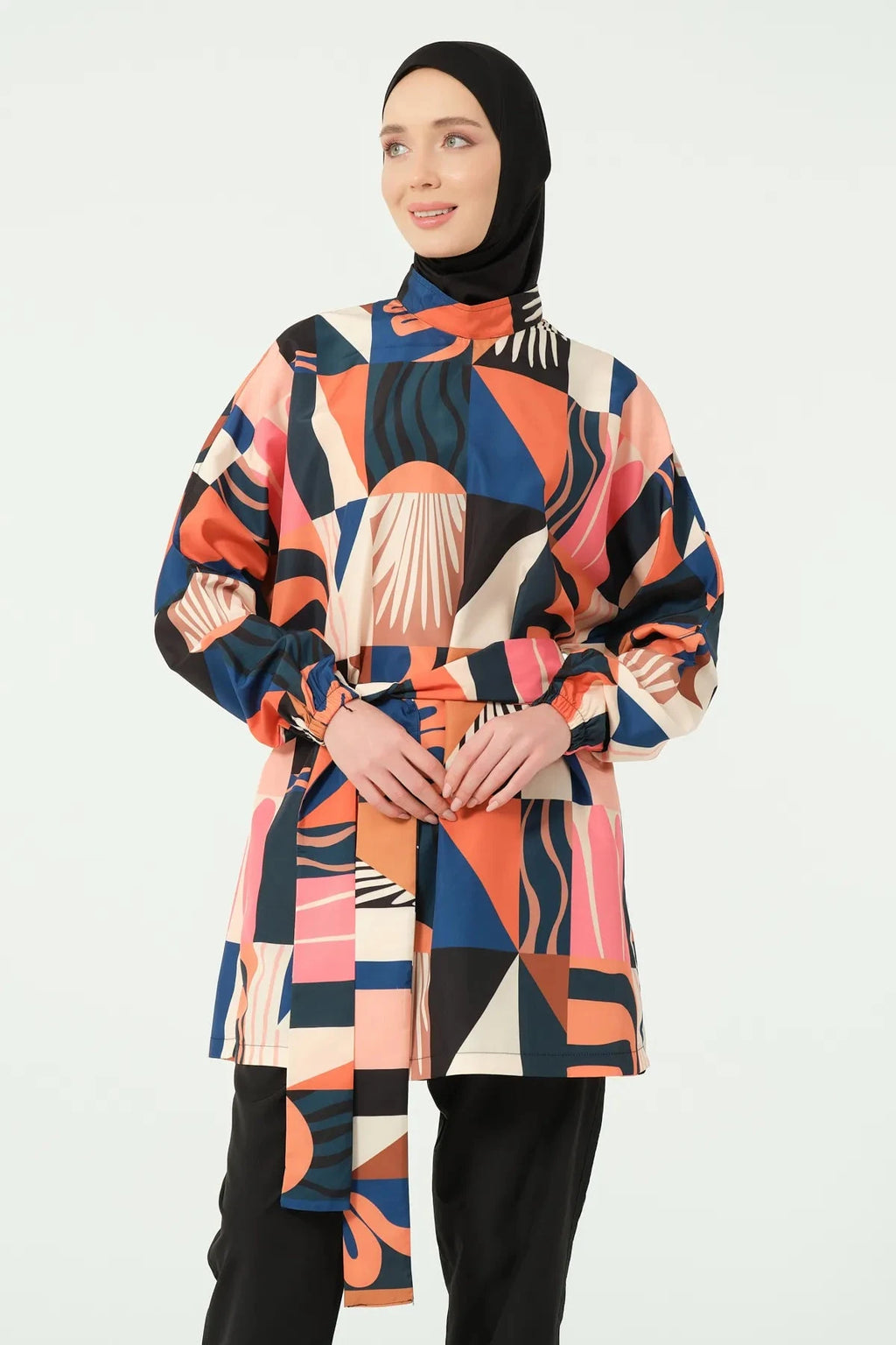 Woman in multi-color geometric print modest swimsuit, front pose.