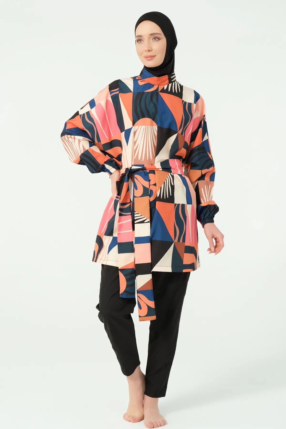 Full view of woman in multi-color geometric print modest swimsuit.