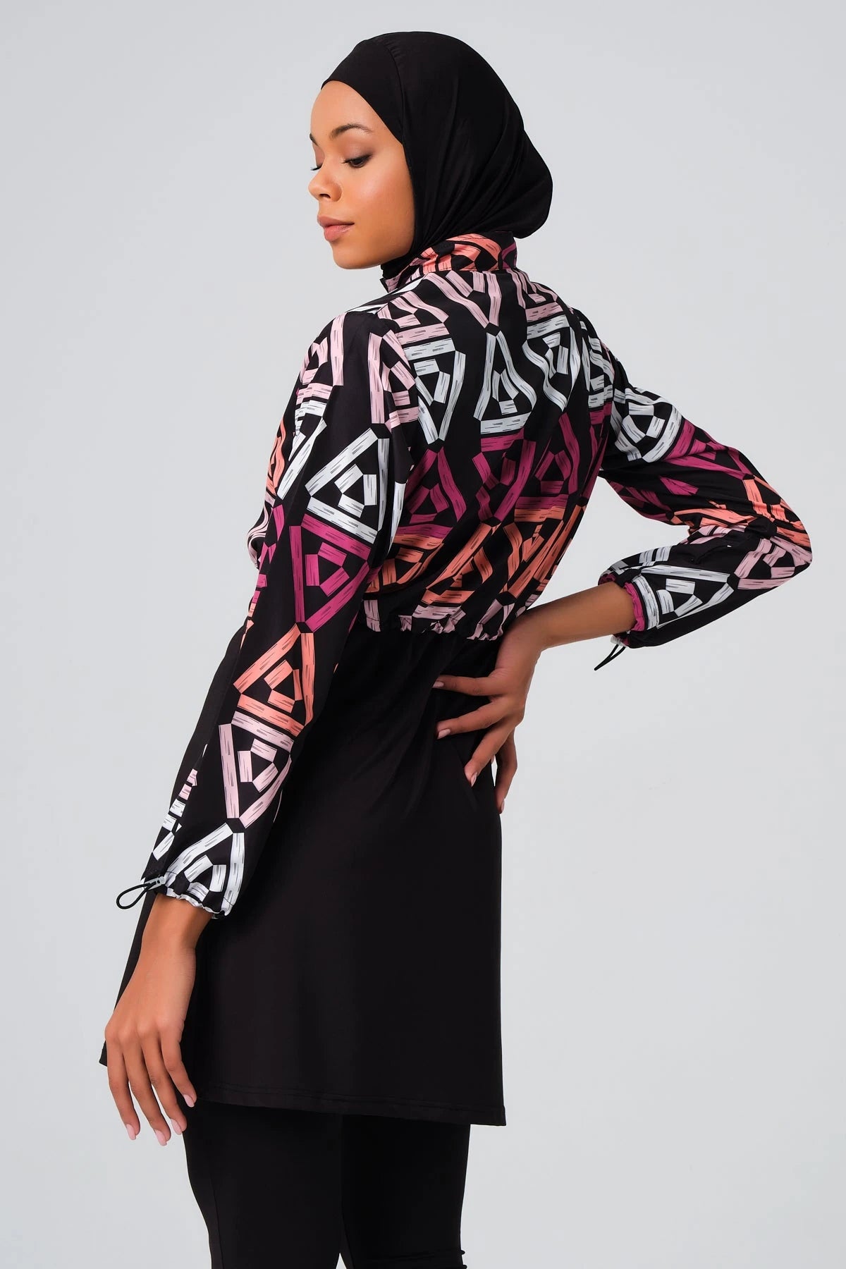 Modest swimsuit set with geometric print jacket, side profile pose.