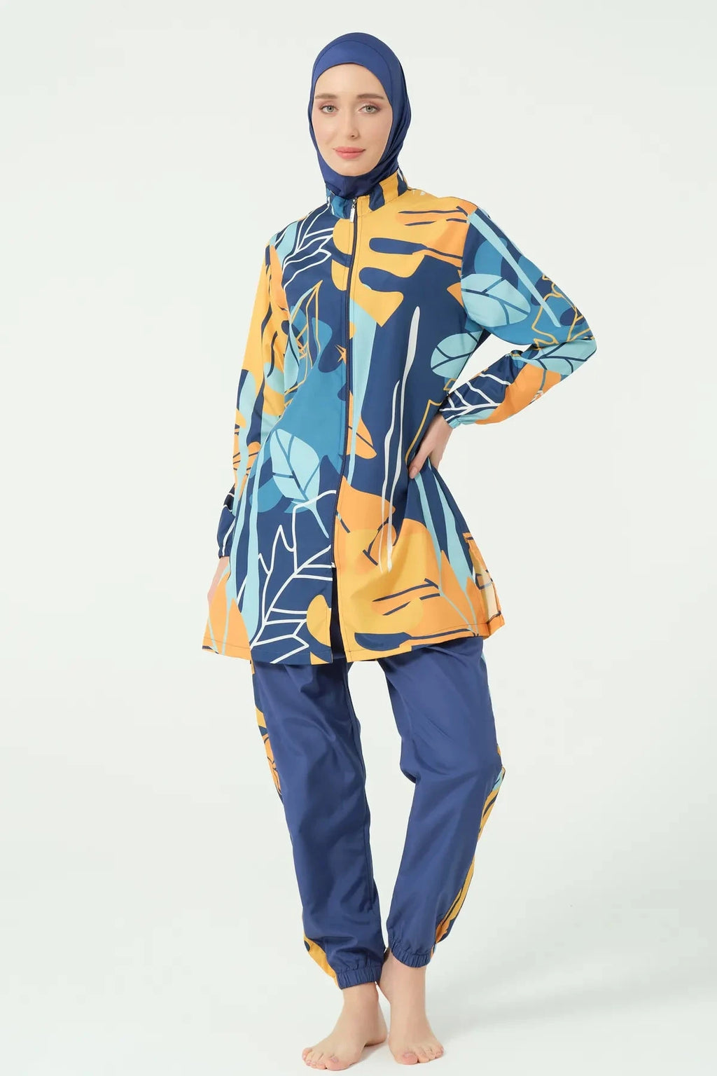 Woman in abstract print modest swimsuit with hand on hip.