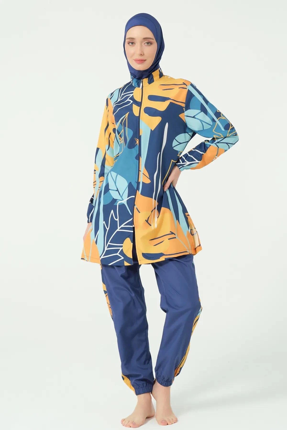 Woman in abstract print modest swimsuit with hand on hip.