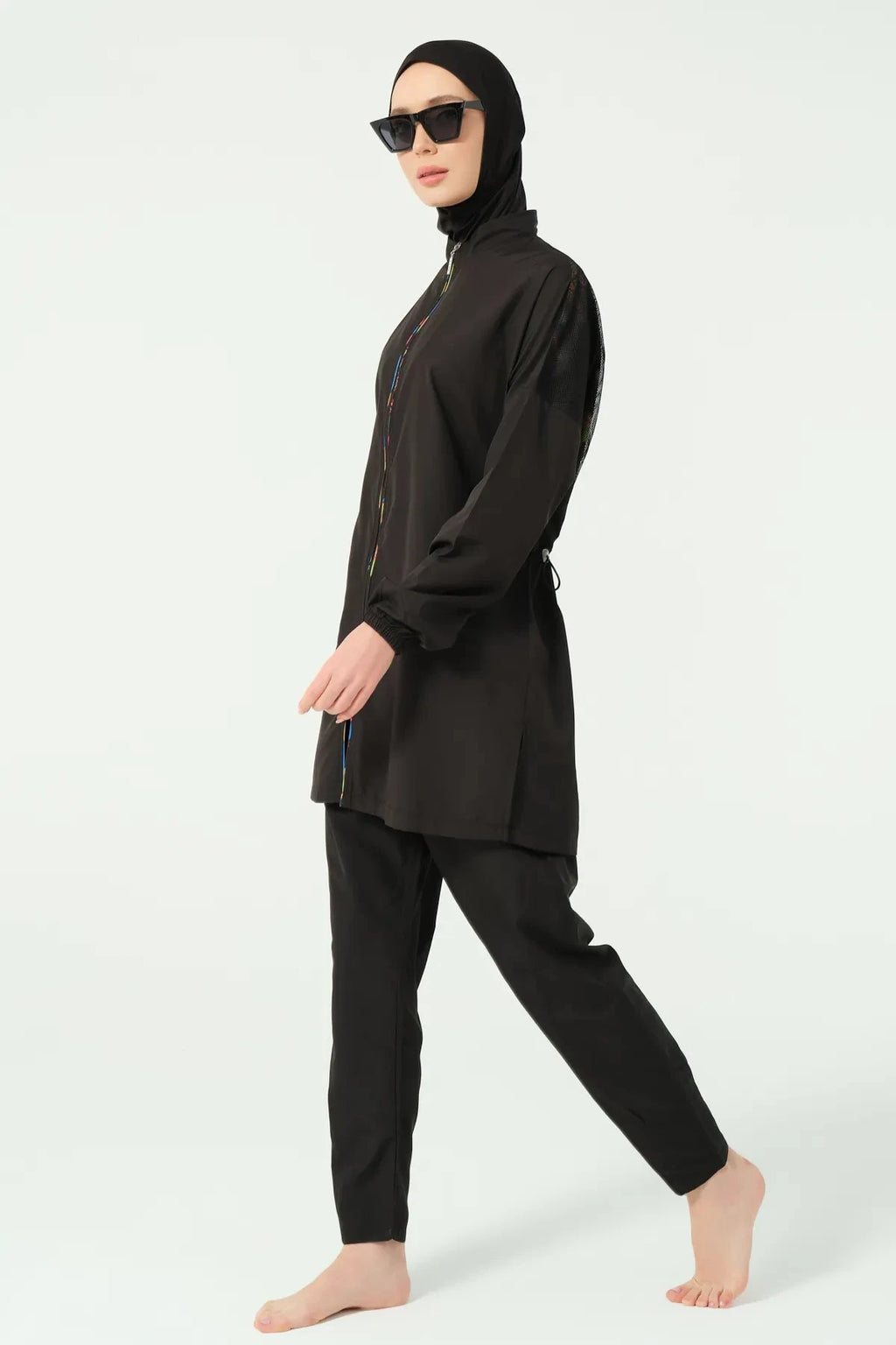 Black modest swimwear side view with hijab and sunglasses.
