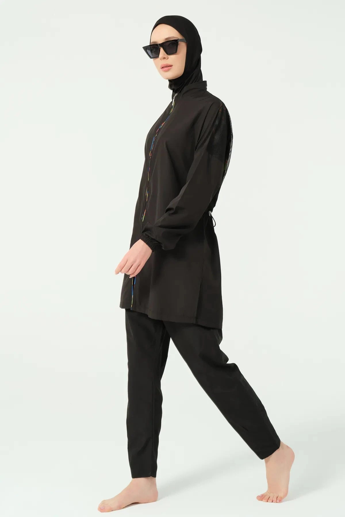 Black modest swimwear side view with hijab and sunglasses.