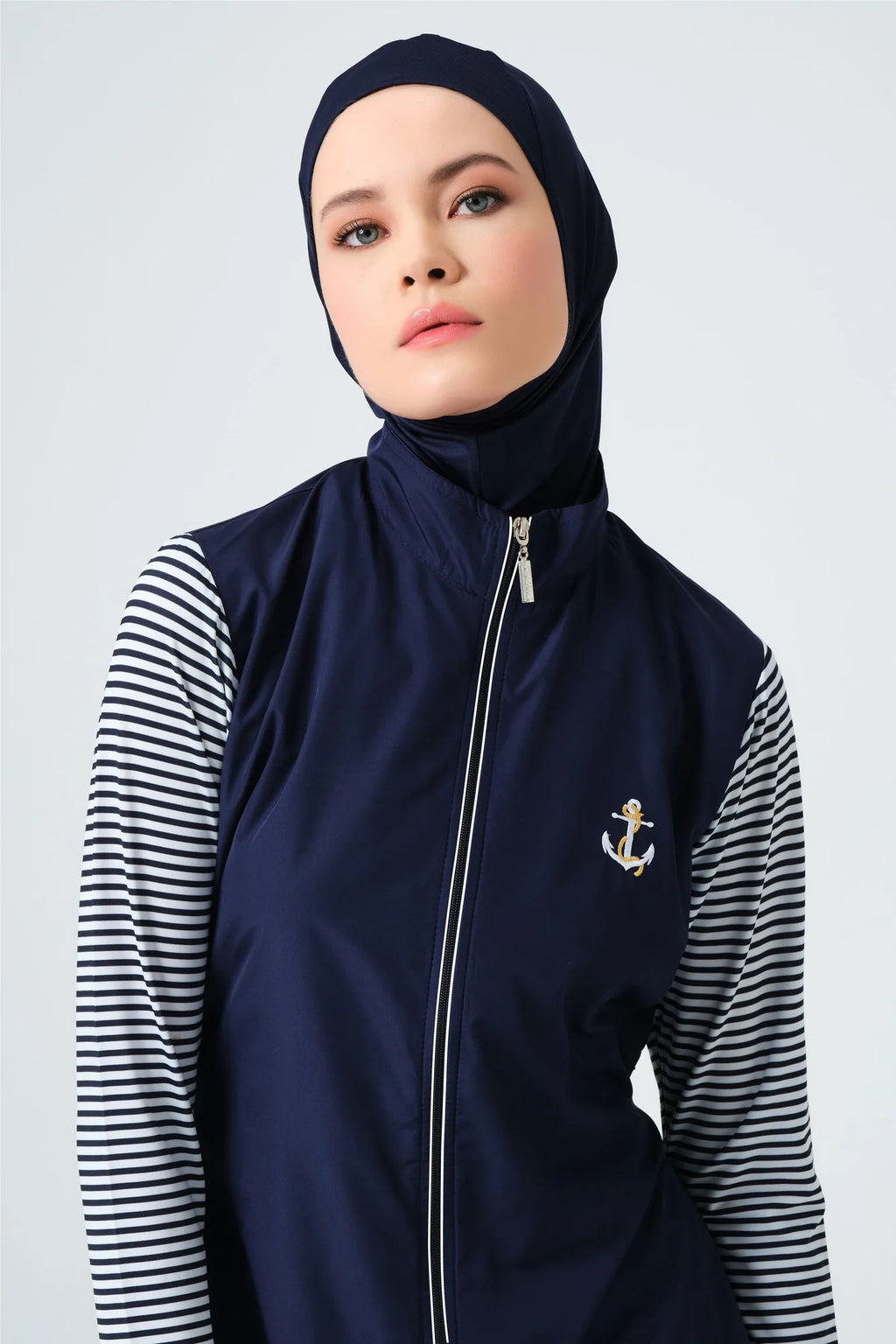 Close-up of navy burkini top with gold anchor and striped sleeves.