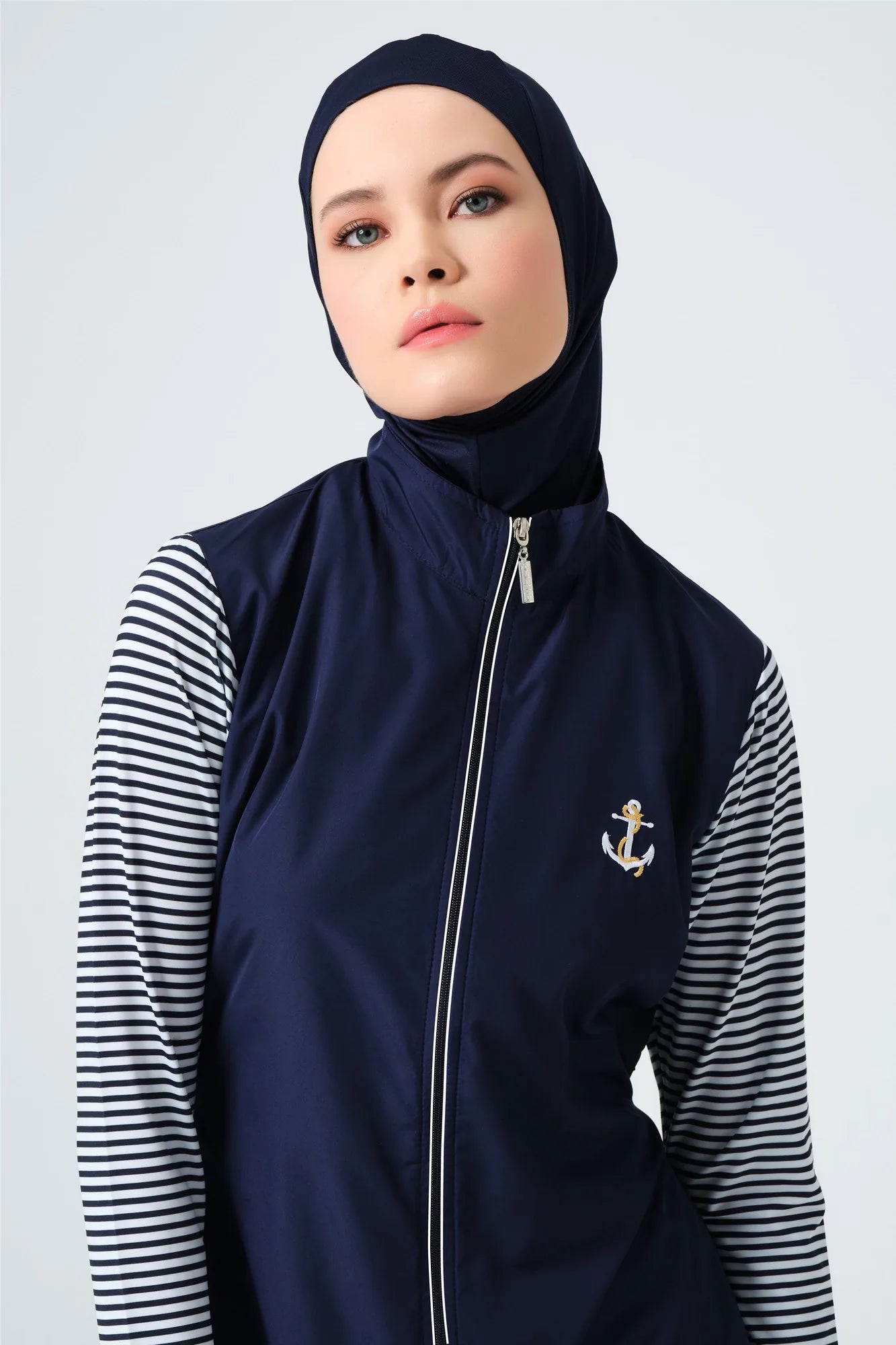 Close-up of navy burkini top with gold anchor and striped sleeves.