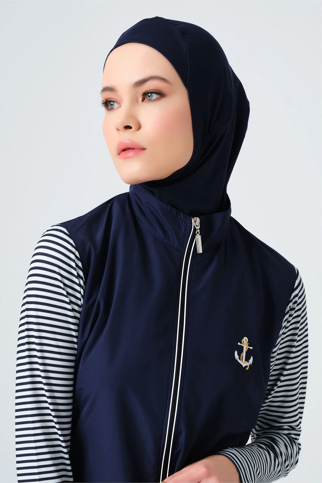 Close-up of model's face wearing navy hijab and burkini top.