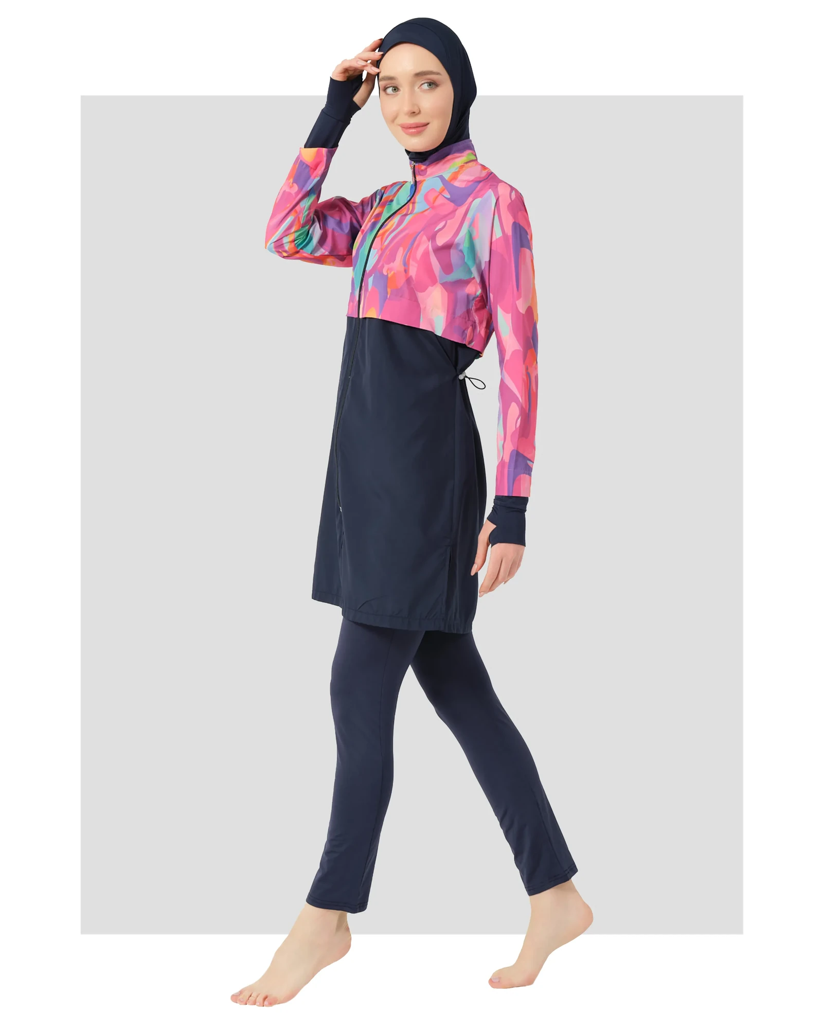 Model wearing abstract print burkini with navy lower and hijab, front view.