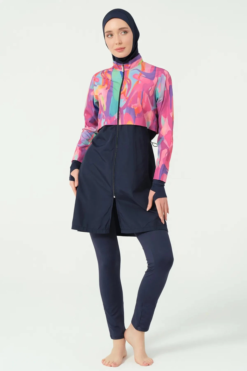 Model in abstract print burkini, front view, hands on hips, with zipper detail.