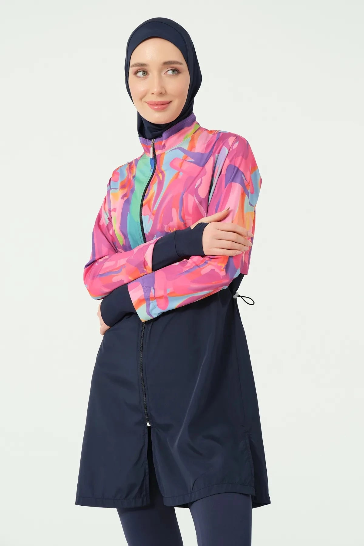 Model in abstract print burkini, upper body, with arms crossed.