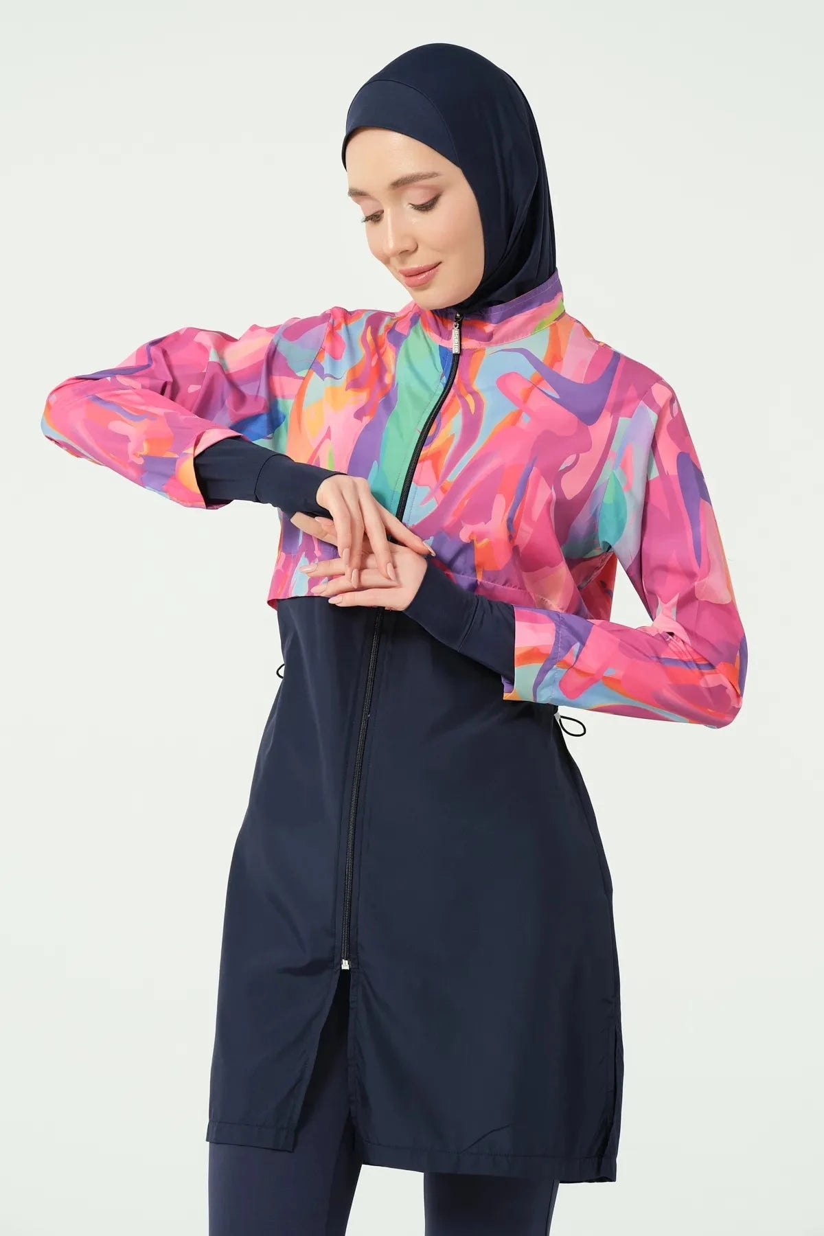 Model in abstract print burkini, upper body, adjusting front zipper.