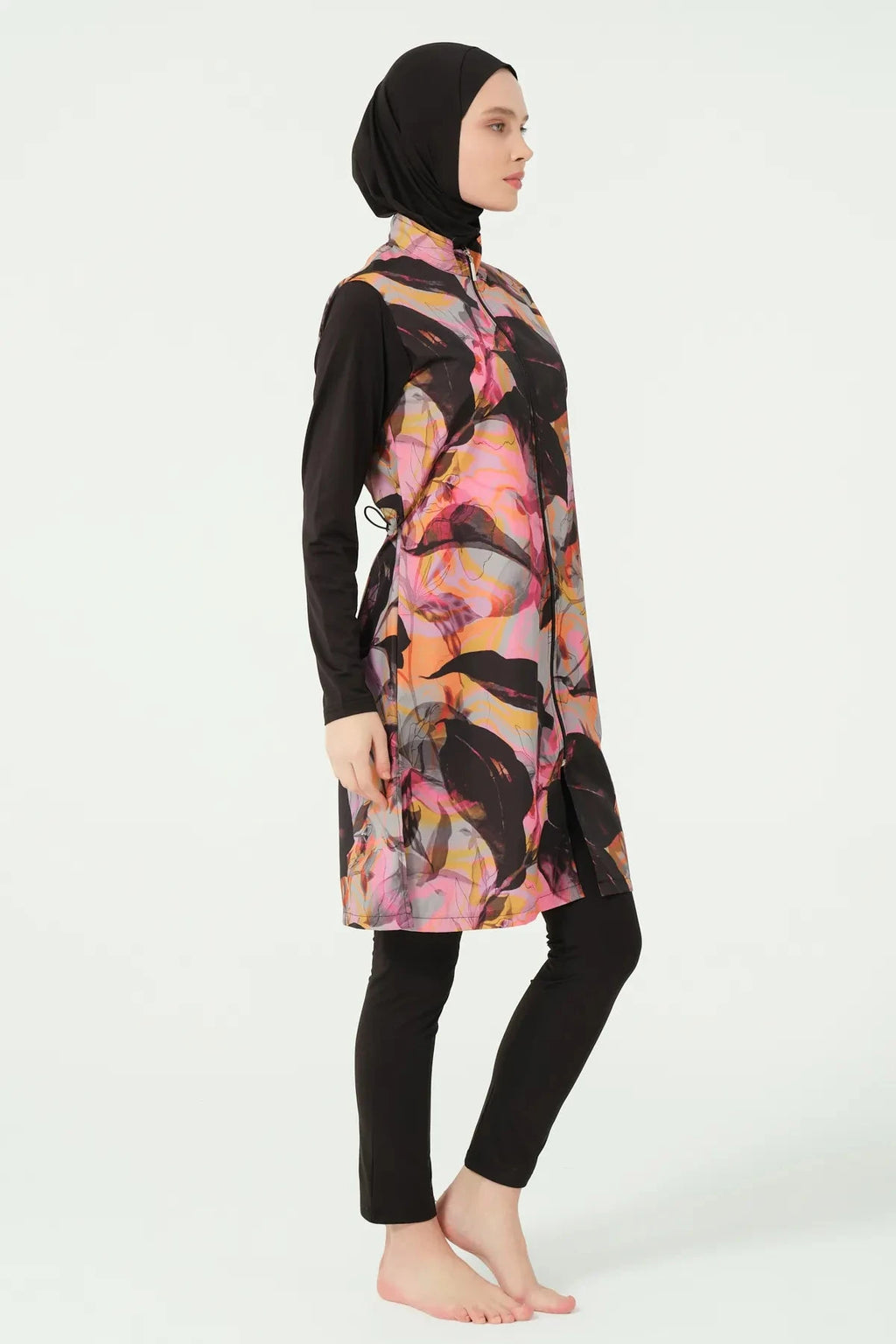 Abstract print burkini top with black sleeves and swim pants, side view.