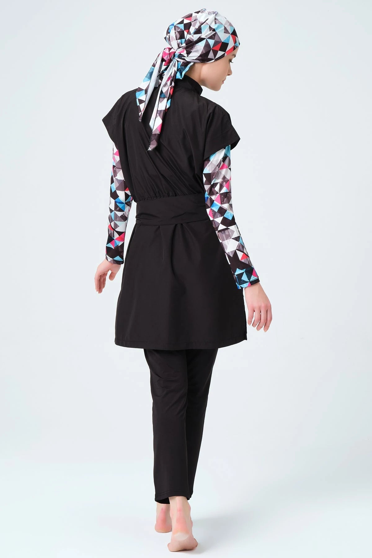 Back view of black layered burkini with geometric print sleeves and hijab.