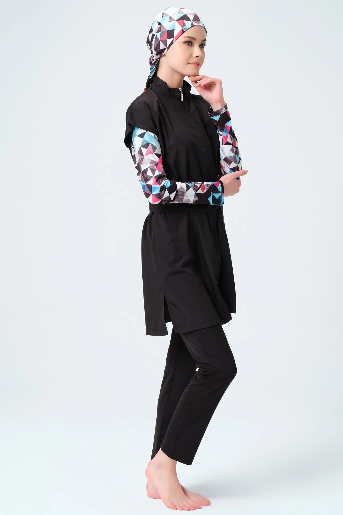 Profile view of black layered burkini with geometric print sleeves and hijab.