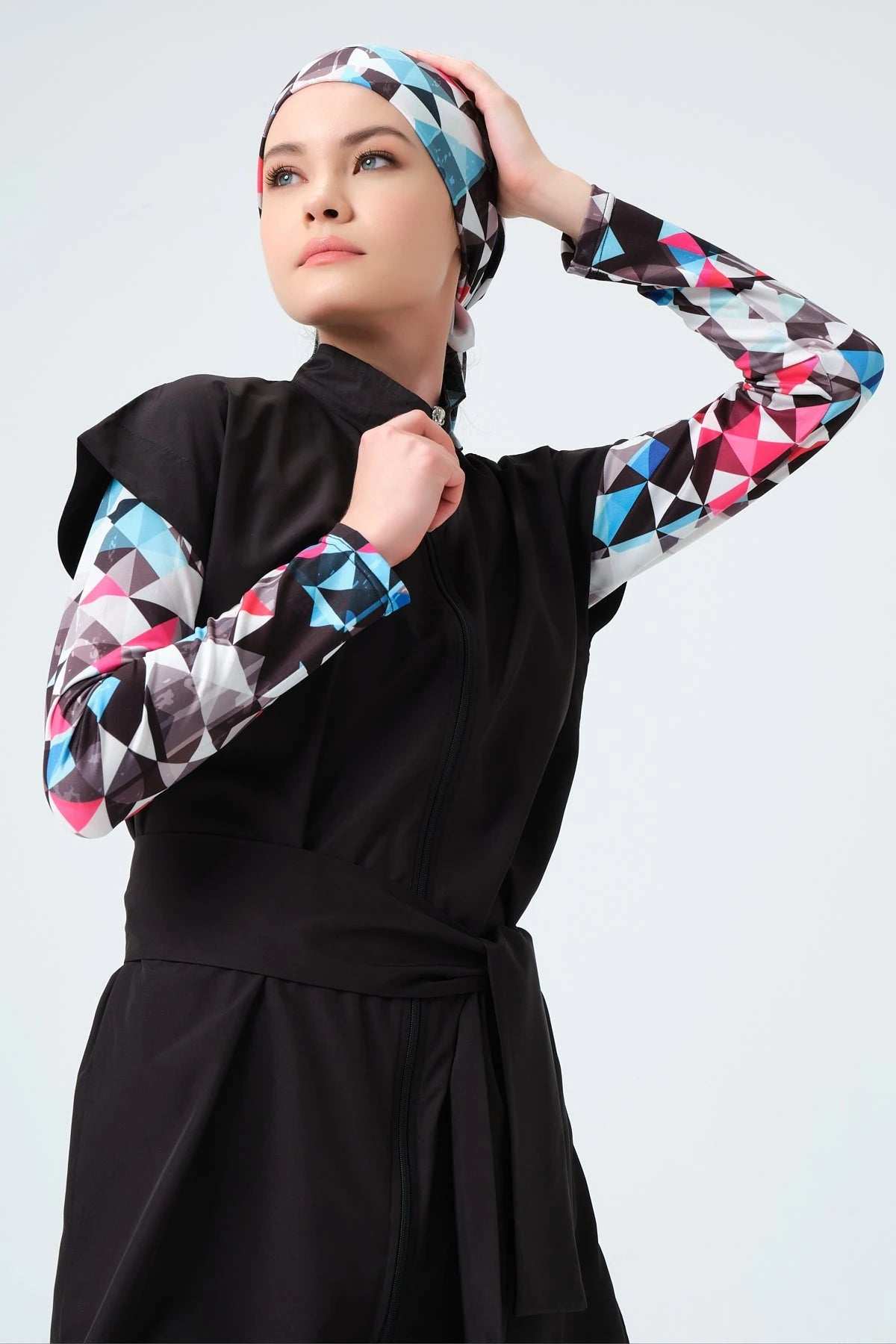 Close-up of black burkini top with geometric print sleeves and hijab.