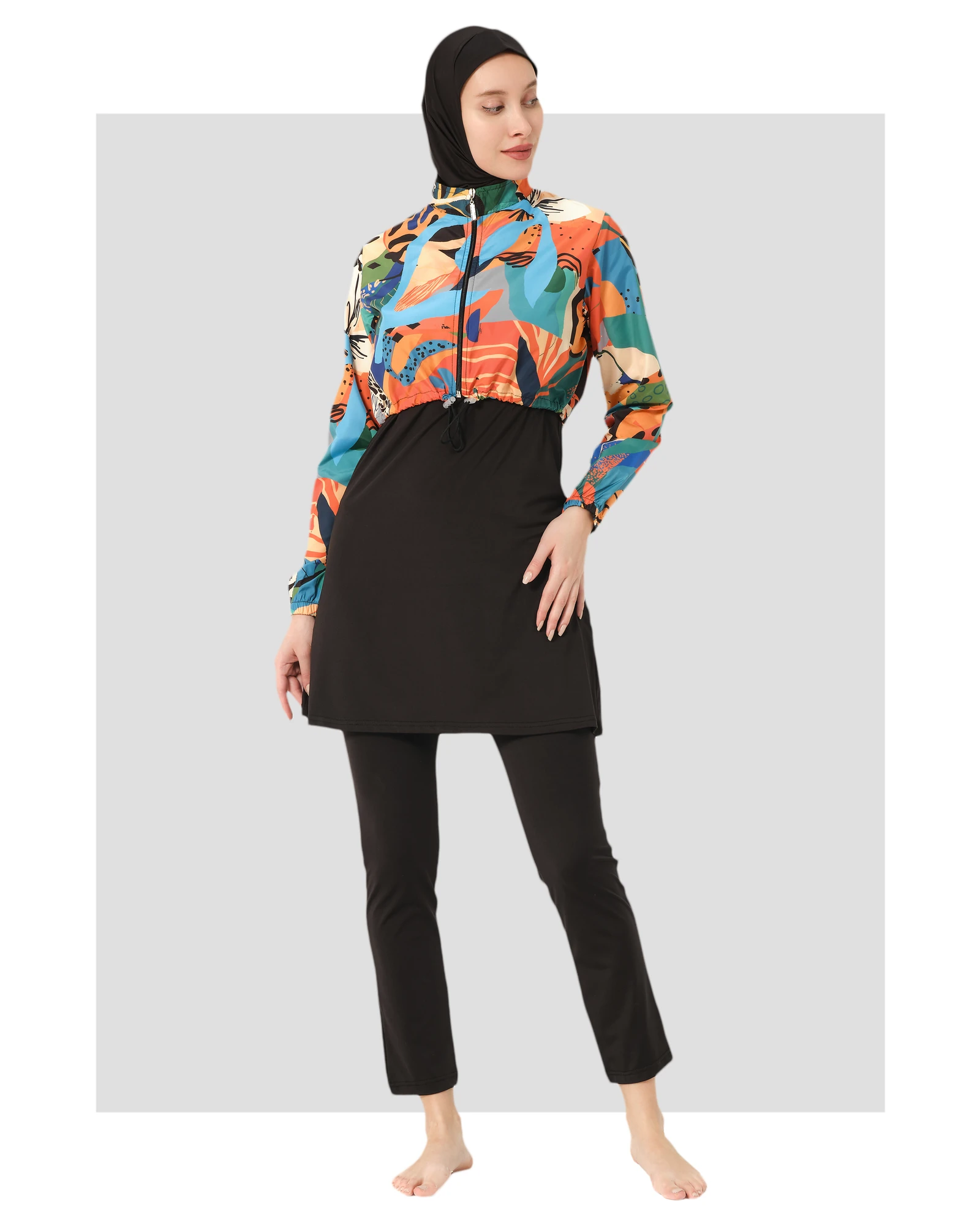 Woman in vibrant abstract print hijab swimwear set, front angle.