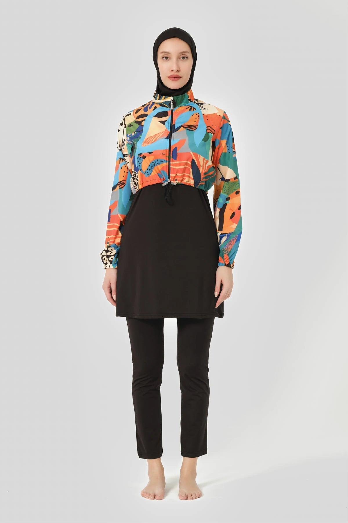 Woman wearing vibrant abstract print hijab swimwear set, full front view.