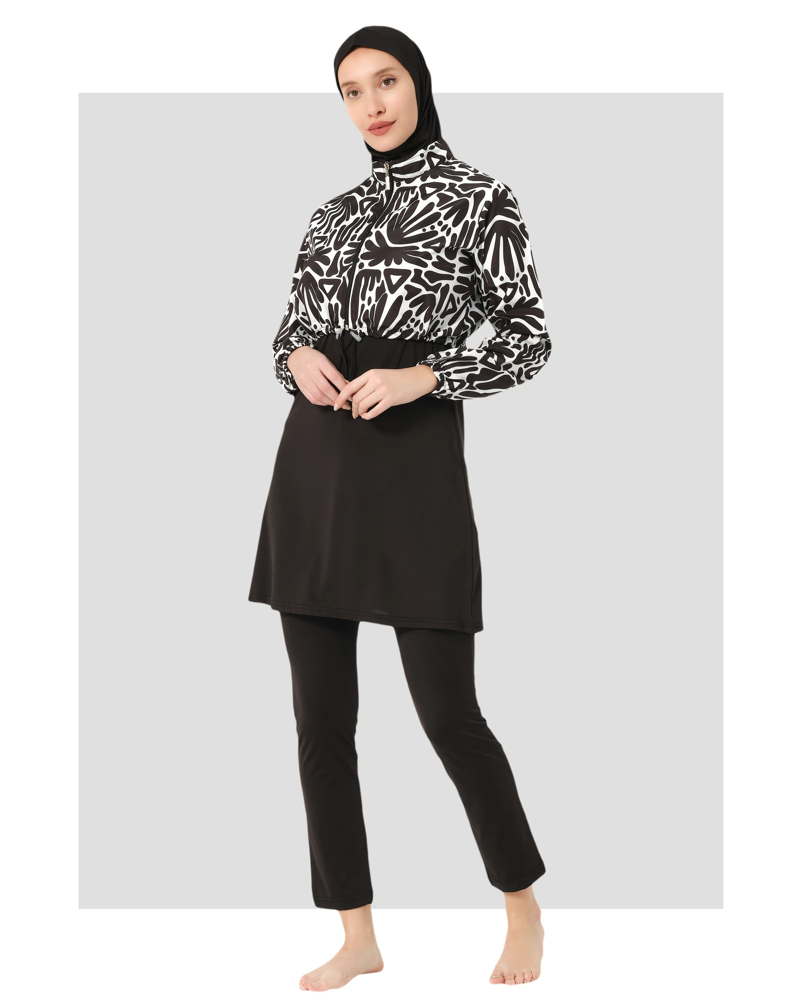 Woman in monochrome hijab swimwear set with abstract print jacket, front angle.