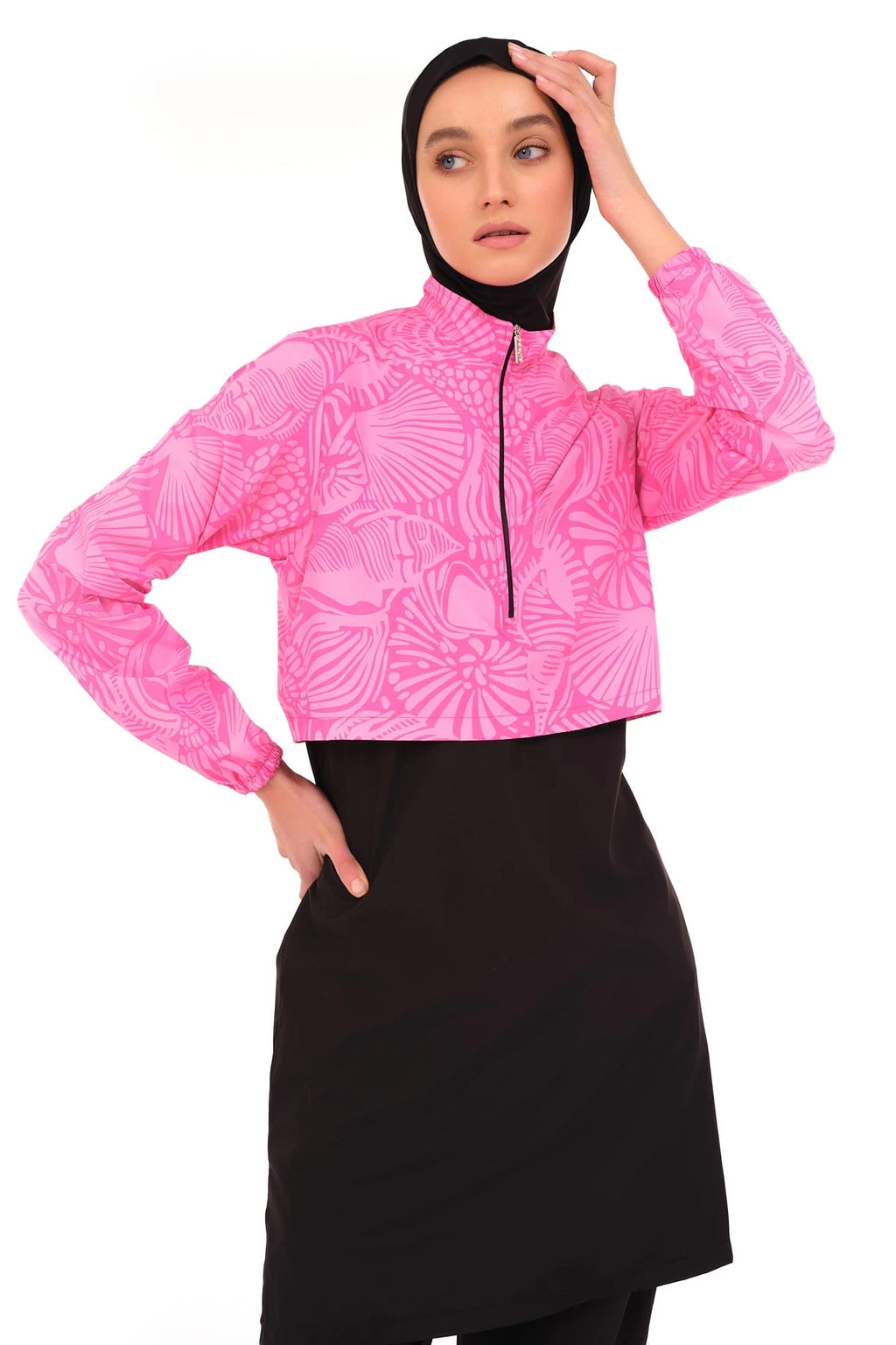 Close-up of pink patterned cropped jacket with black zipper and black hijab.