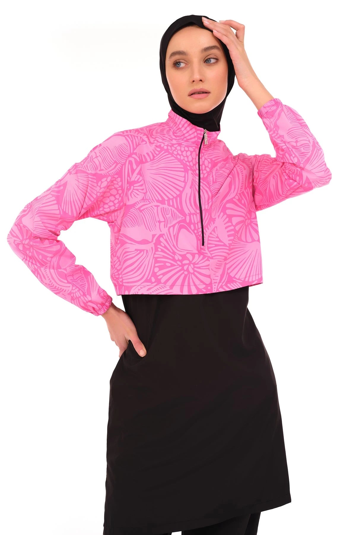 Close-up of pink patterned cropped jacket with black zipper and black hijab.