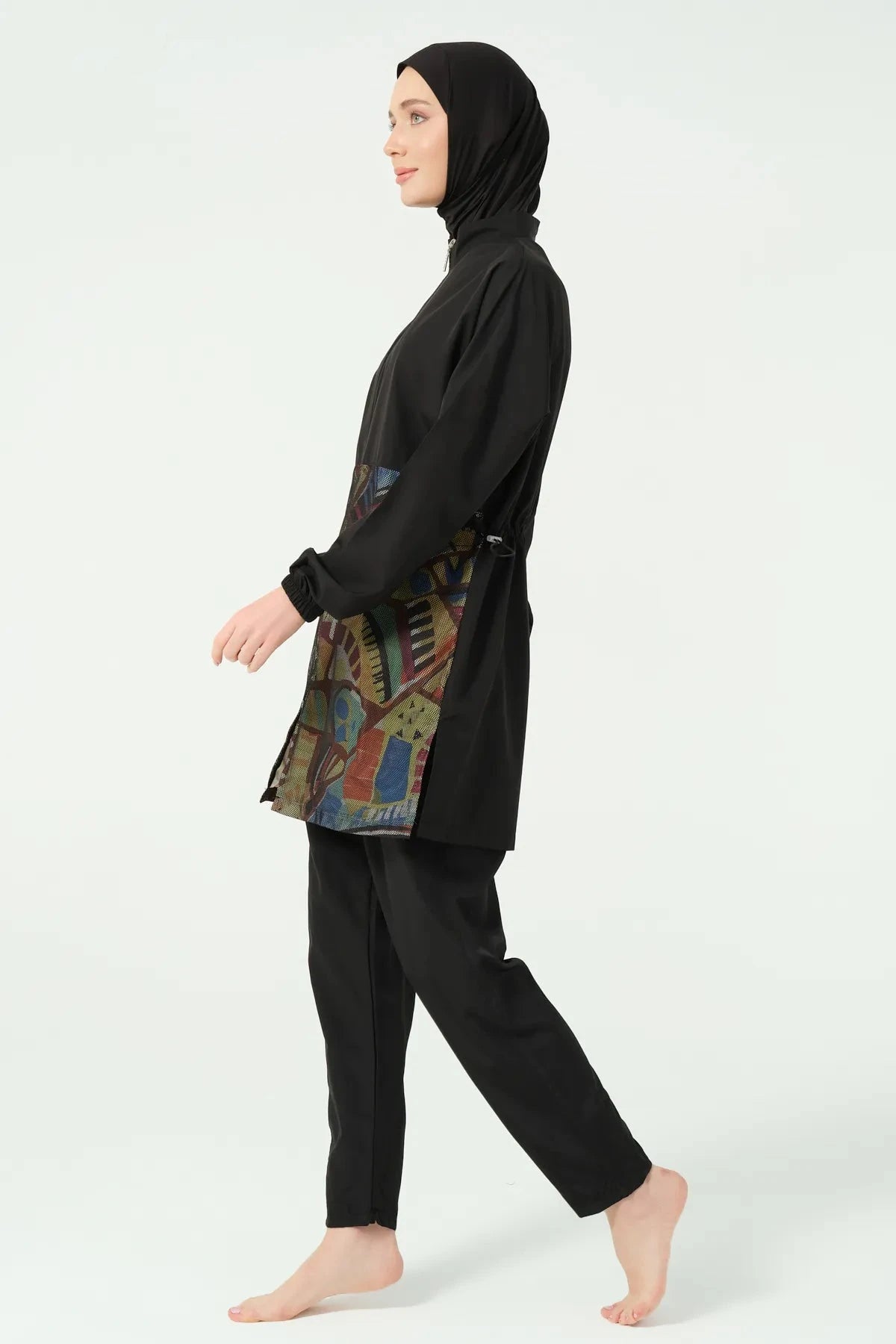 Black burkini set with geometric print top, side view walking.