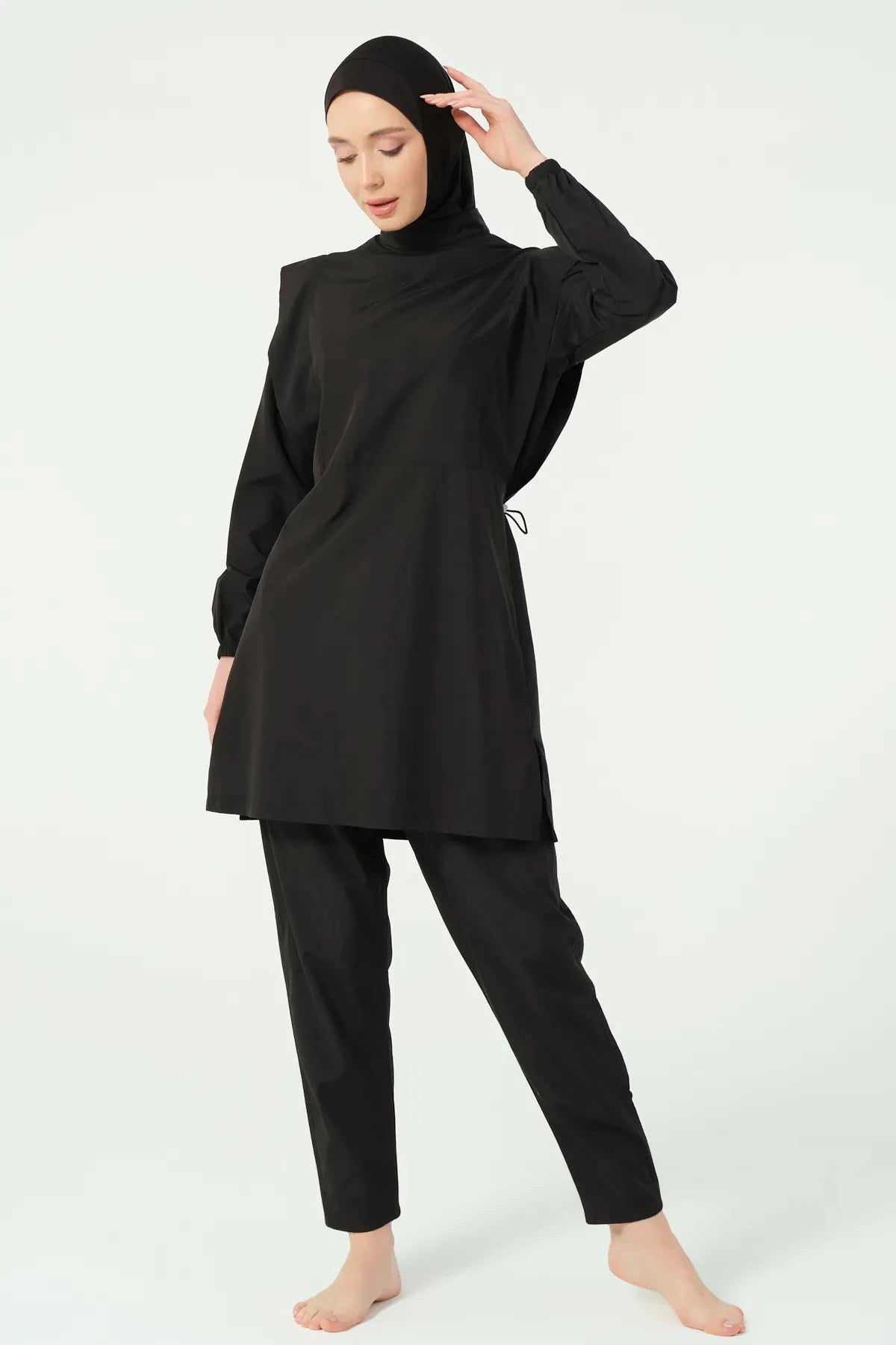 Black hijab swimwear angled view with model posing against white background.
