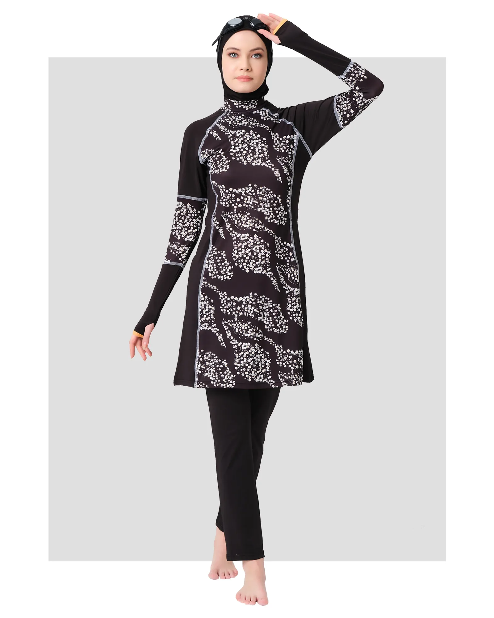 Black floral burkini set front view on model with head covering.