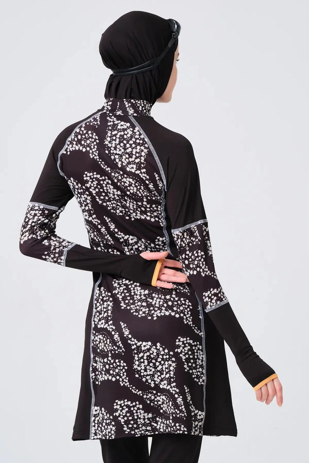 Close-up back view of black floral burkini showing sleeve detail.