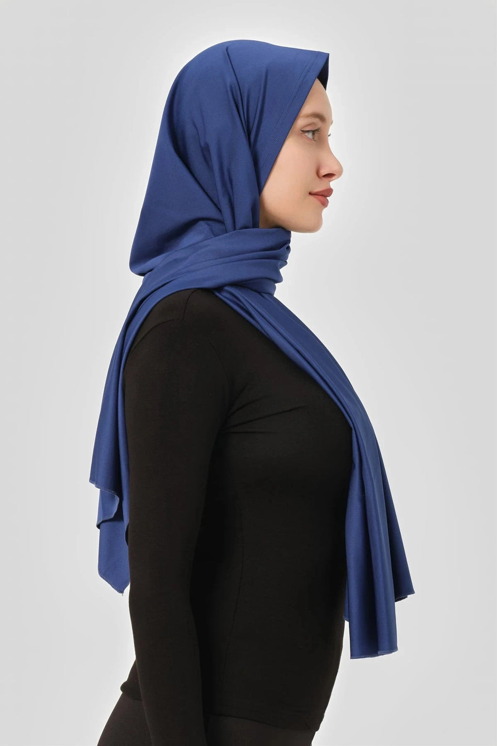Blue swim hijab worn with black long-sleeved top, three-quarter view.