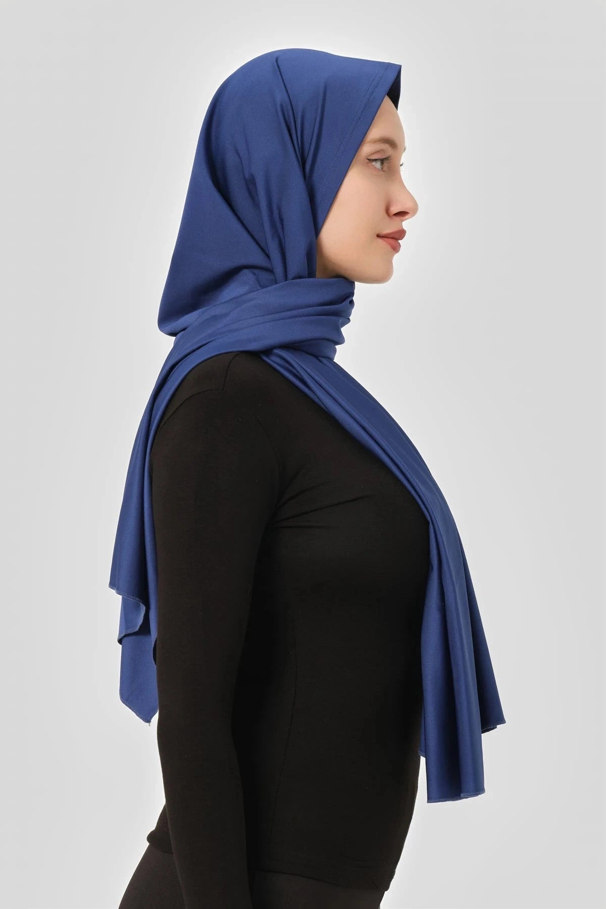 Blue swim hijab worn with black long-sleeved top, three-quarter view.