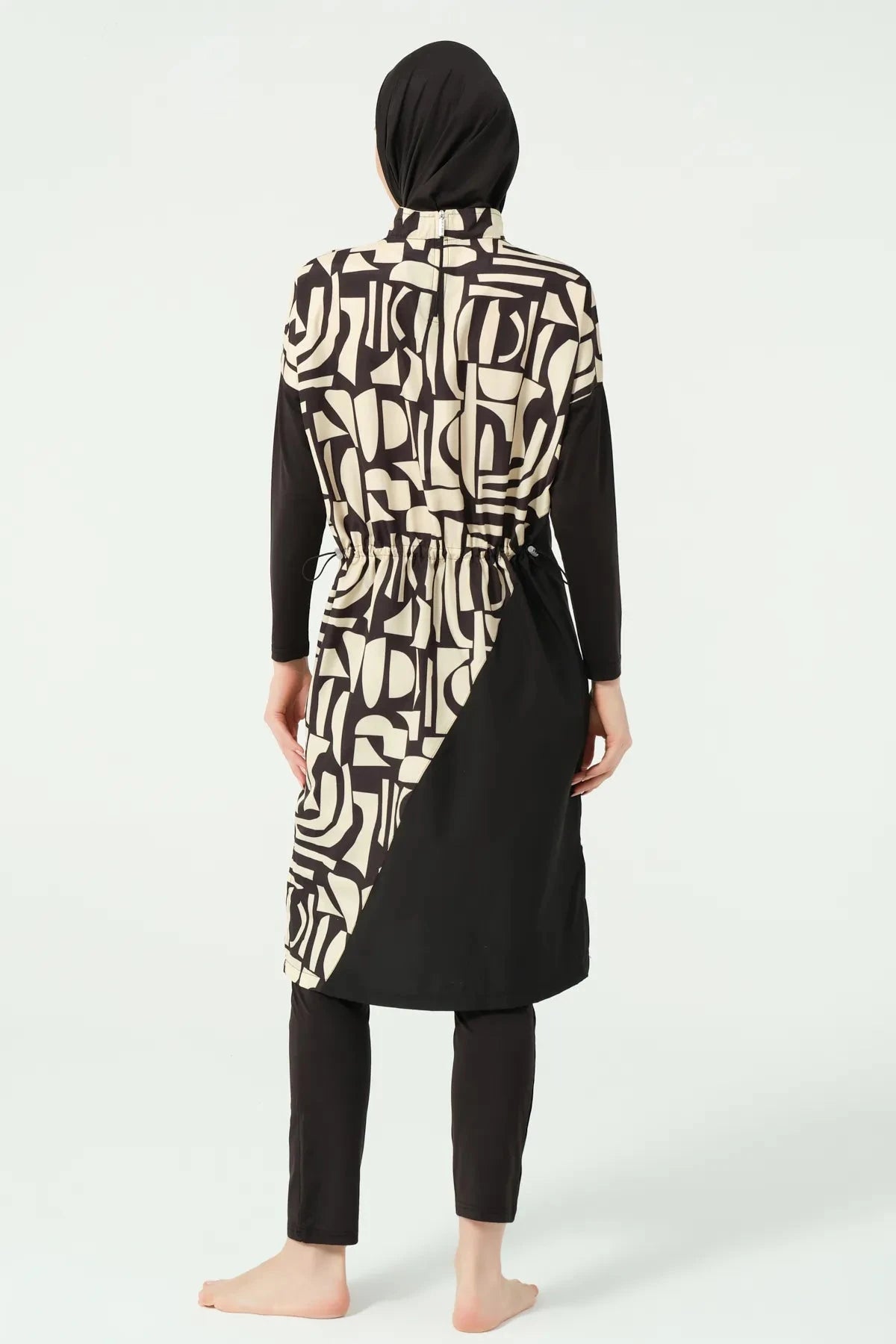 Model in black and beige geometric print burkini back view.
