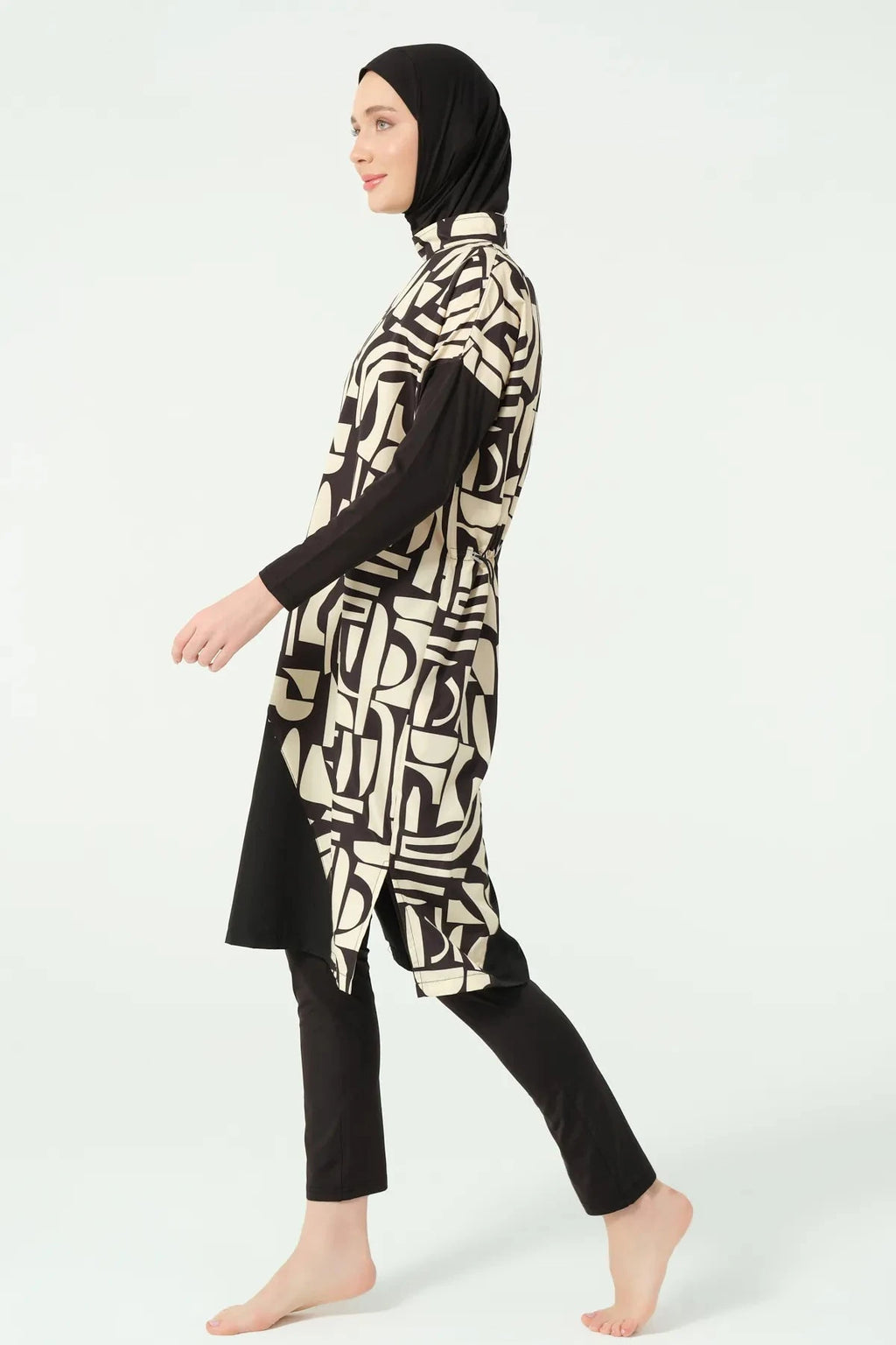 Model walking in black and beige geometric print burkini side view.