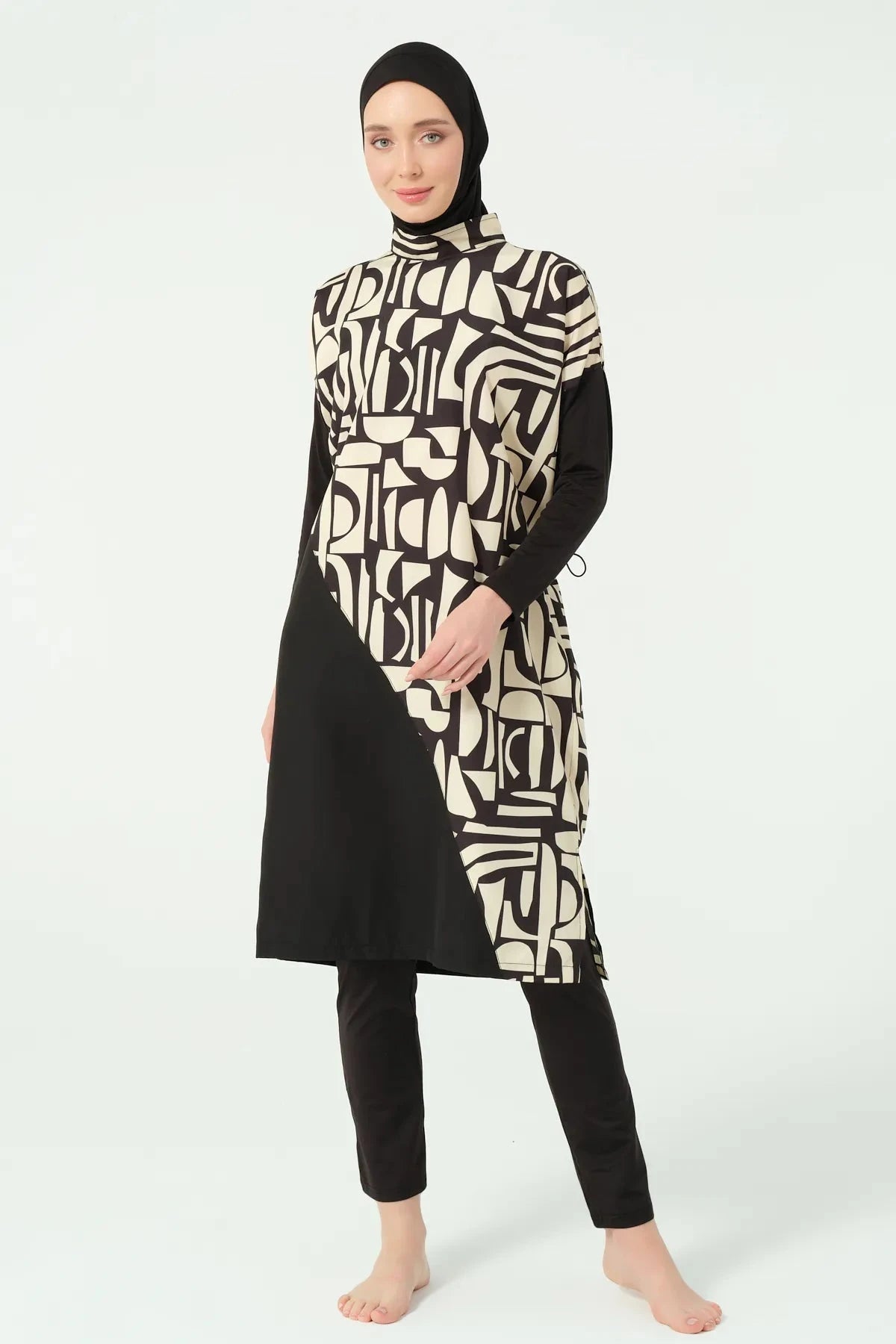 Model posing in black and beige geometric print burkini front.