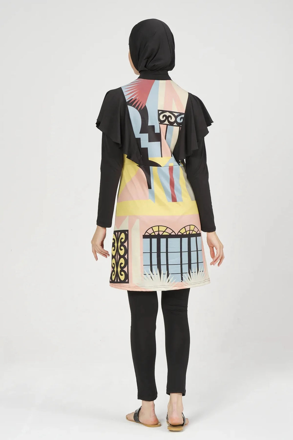 Model wearing abstract print modest swimsuit set back view with black hijab.