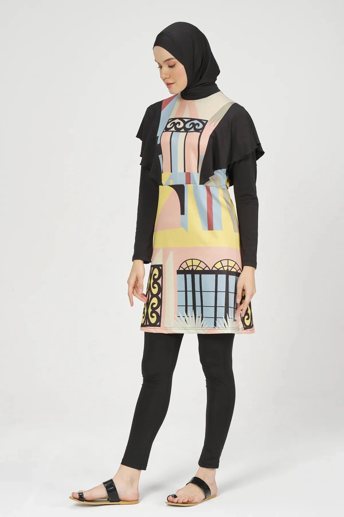 Model wearing abstract print modest swimsuit set side left view.