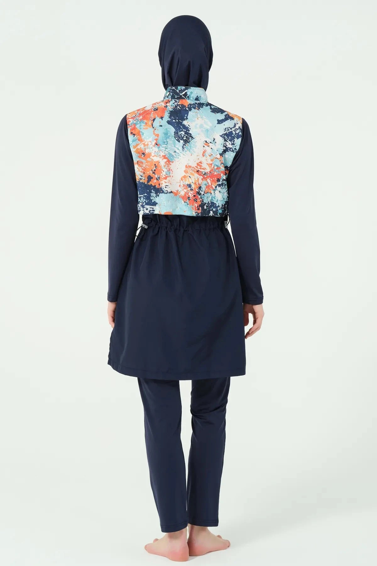 Model wearing navy burkini with abstract print top, back view.