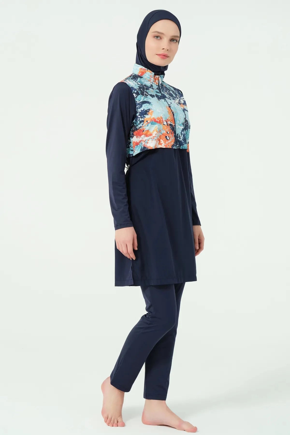 Model wearing navy burkini with abstract print top, side view.