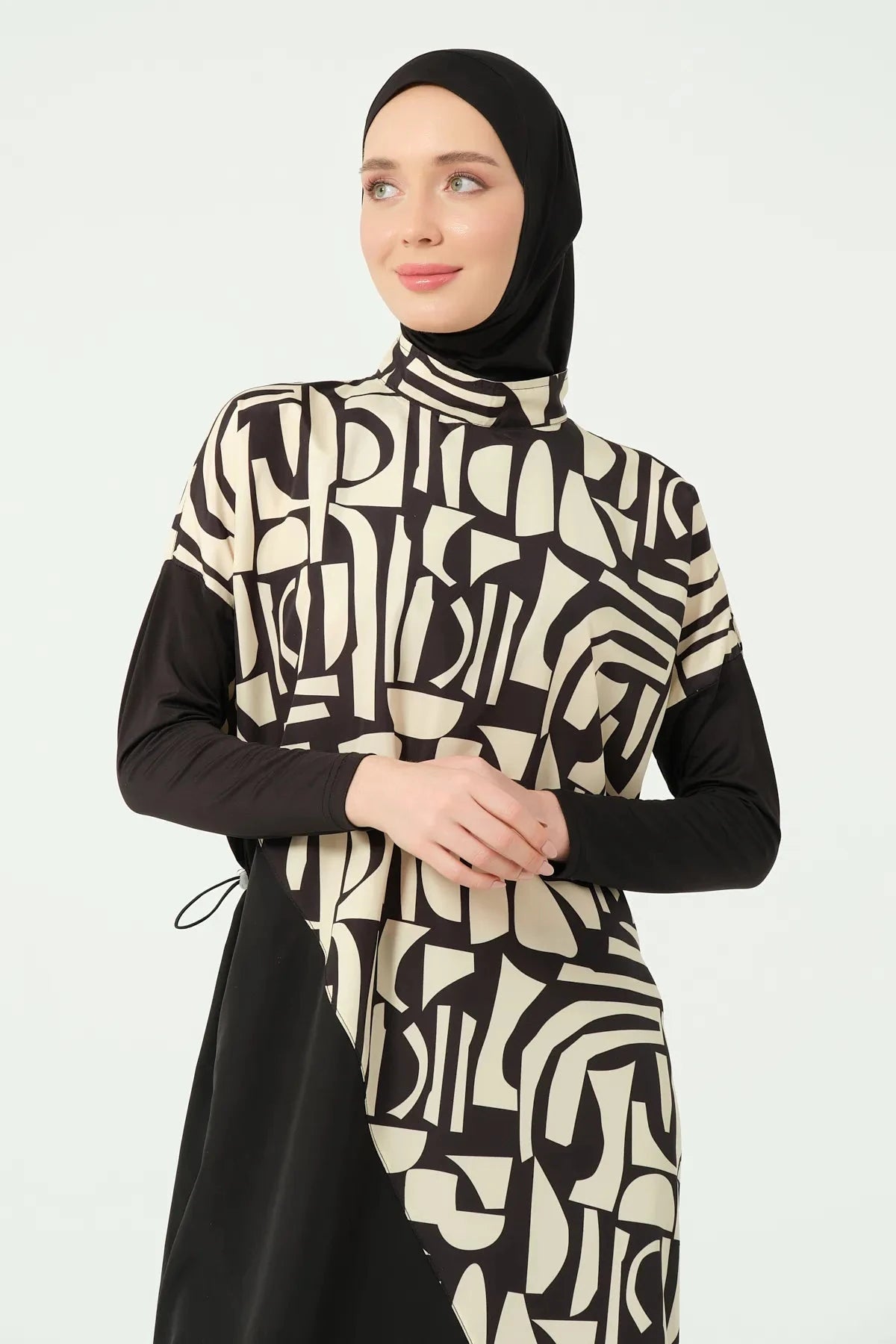 Close-up of model wearing black and beige abstract print modest swimsuit.