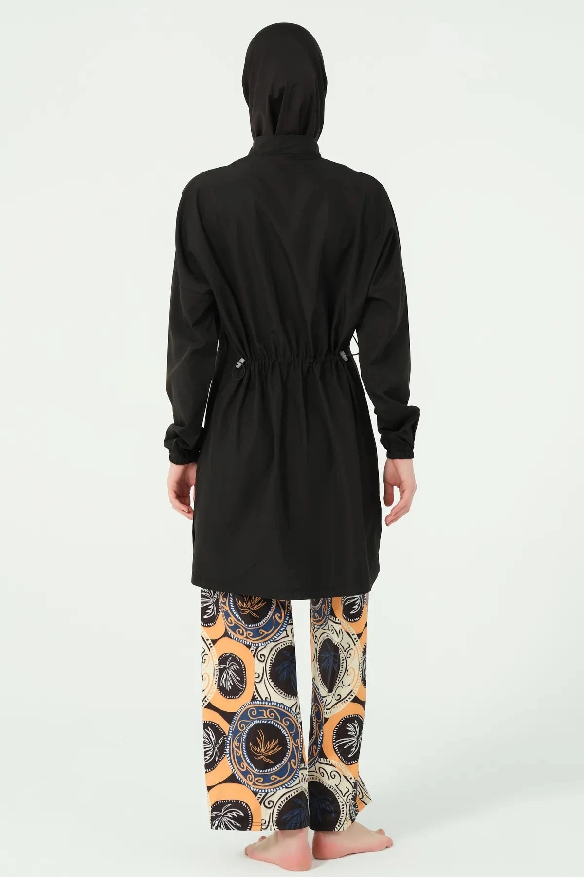 Back view of black tunic with drawstring and printed swim pants.